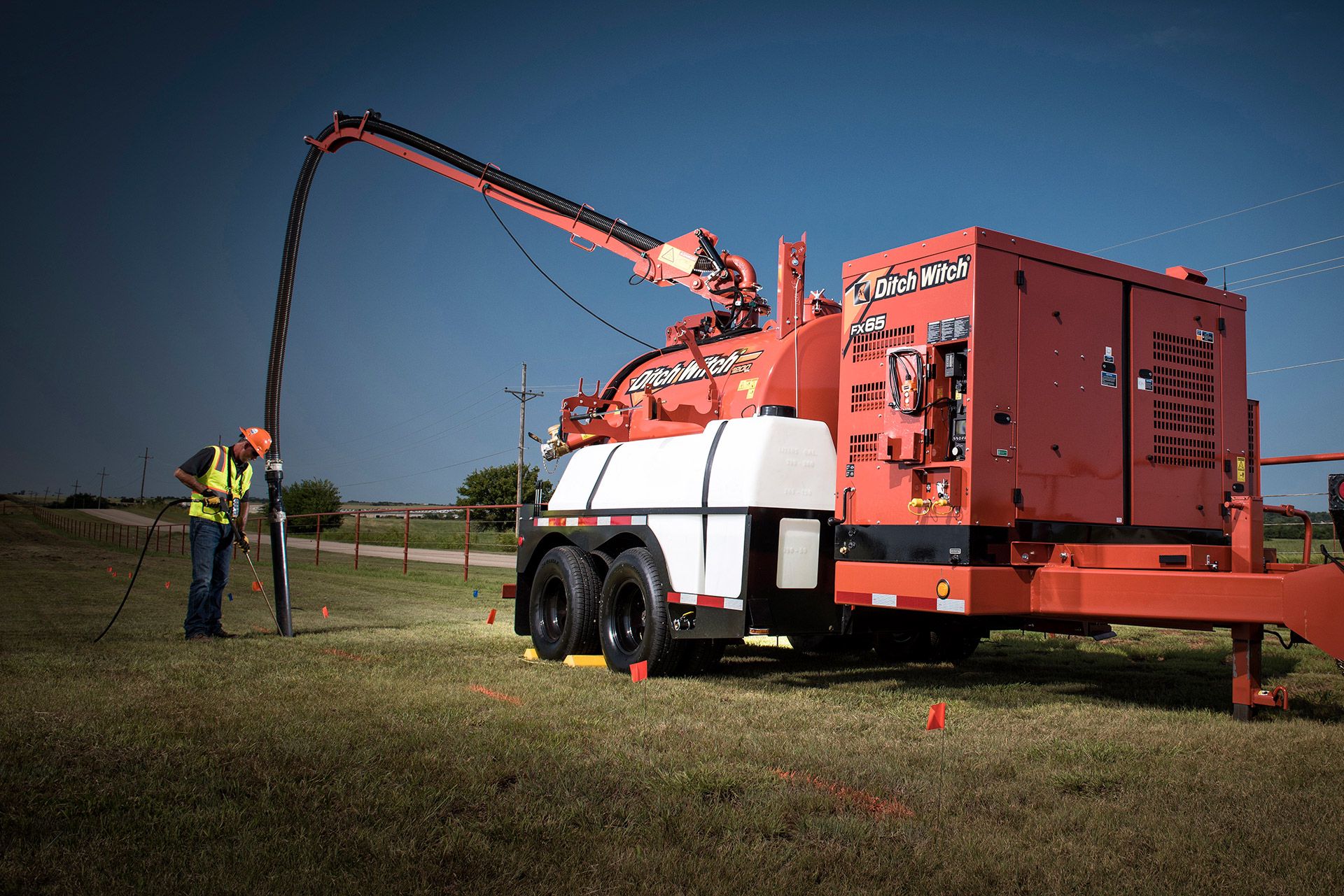 Hydrovac operator using Ditch Witch FX65 for utility excavation on open field site